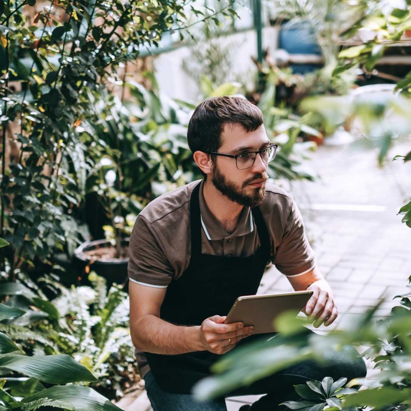 young-man-gardener-in-glasses-and-apron-with-digit-W9RAKTZ.jpg