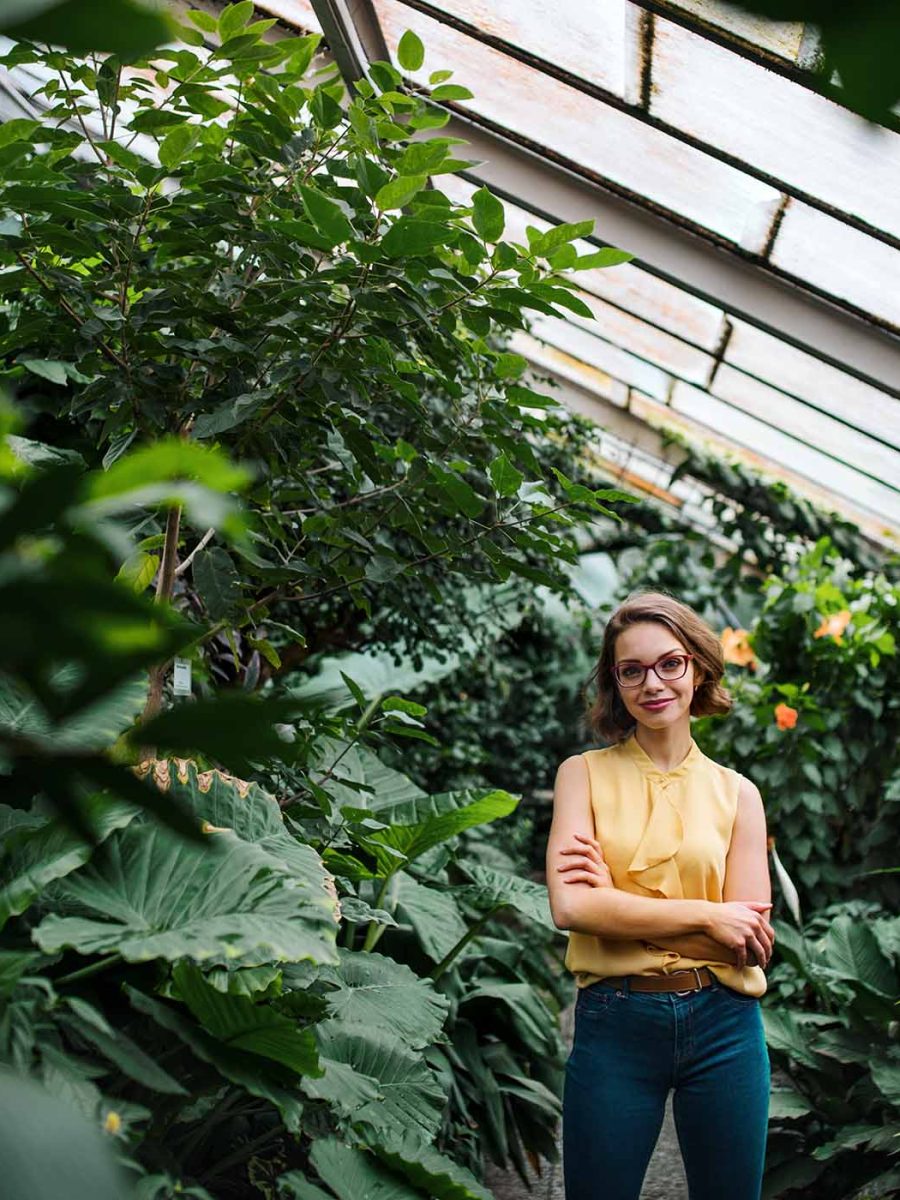 young-woman-standing-in-greenhouse-in-botanical-ga-NDFBT8H.jpg